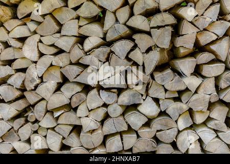 Hintergrund des gehefteten Brennholzes, das im Wald trocknet Stockfoto