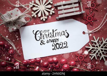 Ein Label mit englischer Kalligraphie Frohe Weihnachten und Ein Happy 2022. Rotweihnachtsentöter Wie Schlitten, Geschenk Und Snowlfakes Stockfoto