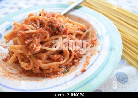 bucatini mit Fischtomatensoße mit roher Pasta Stockfoto