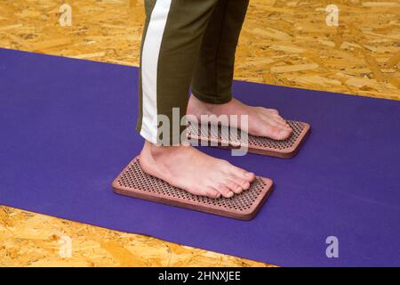 Praxis des Stehens auf Nägeln. Nahaufnahme eines Yoga-Mannes, der auf einem Sadhu-Brett mit scharfen Nägeln steht. Hölzernes Sadhu-Brett mit Nägeln für die Sadhu-Praxis Stockfoto