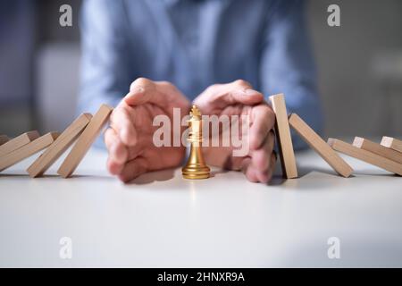 Fallende Domino-Stücke. Business Risk Und Chess King Stockfoto