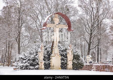 Kruzifix auf dem Westfriedhof in münchen bei starkem Schnee im Winter Stockfoto