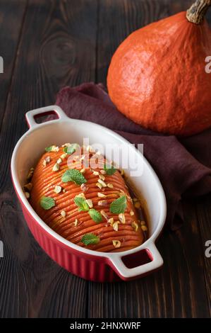 Gebackener hasselback-Kürbis, mit Karamell in der Backform glasiert Stockfoto