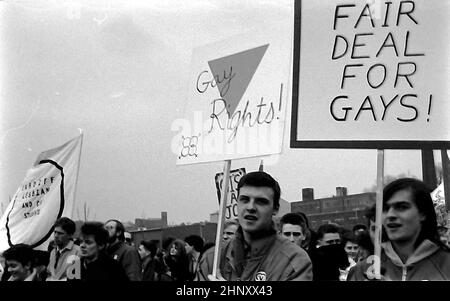 Die Menschen marschieren, halten Plakate mit den Aufsagen „Fair Deal for Homosexuell“ und „Gay Rights“, um sich Anfang der 1980er Jahre im Großraum Manchester für gleiche Rechte für Lesben und Schwule einzubringen. Stockfoto