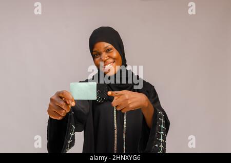 Junge schöne afrikanische Frau mit leerer Karte und lächelnd Stockfoto