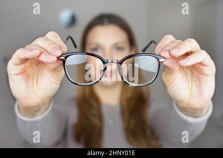 Schlechtes Sehvermögen. Mädchen hält Brille zum Sehen in ihren Händen. Stockfoto