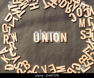 Union Wort in Holzwürfel Alphabet Buchstaben Draufsicht auf Einem rustikalen Papier Hintergrund. Stockfoto