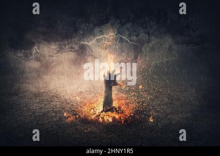 Hand auf Feuer, das aus dem Boden steigt. Surreale Szene mit flammendem Dämonenarm, der aus der Hölle kommt. Halloween-Konzept, gruseliger Hintergrund Stockfoto