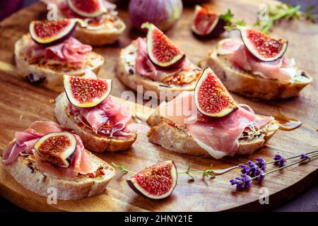 Kleine, offene Sandwiches mit Ciabatta, Proscuitto und frischen Feigen als Appetizer Stockfoto