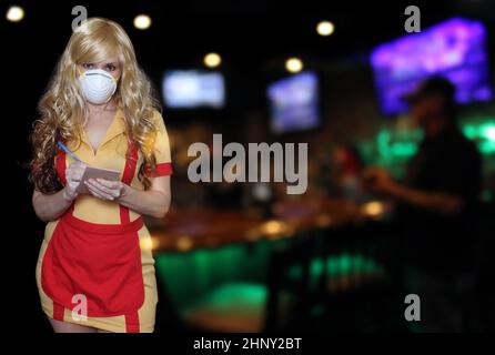 Kellnerin mit N95 Maske halten Bierbecher, flache DOF Fokus auf Bier Stockfoto