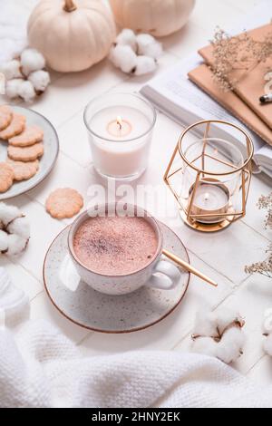 Stillleben im Herbst und Winter mit heißer Schokolade und Kakao, Keksen, Kerzen in Weiß Stockfoto