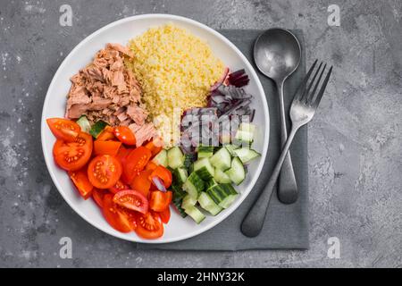 Essen Diät-Konzept, Thunfisch-Salat. Couscous-Salat mit konservierten Thunfisch, Tomaten, Gurken und lila Zwiebeln auf dem Tisch. Speicherplatz kopieren. Stockfoto