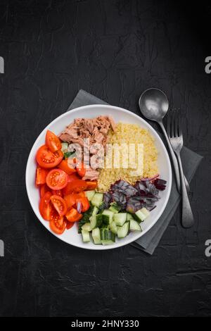 Essen Diät-Konzept, Thunfisch-Salat. Couscous-Salat mit konservierten Thunfisch, Tomaten, Gurken und lila Zwiebeln auf dem Tisch. Speicherplatz kopieren. Stockfoto