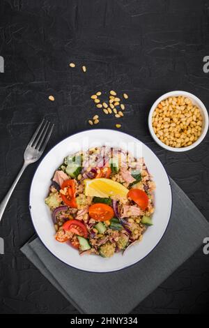 Essen Diät-Konzept, Thunfisch-Salat. Couscous-Salat mit konservierten Thunfisch, Tomaten, Gurken und lila Zwiebeln auf dem Tisch. Speicherplatz kopieren. Stockfoto