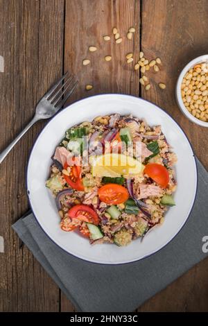 Essen Diät-Konzept, Thunfisch-Salat. Couscous-Salat mit konservierten Thunfisch, Tomaten, Gurken und lila Zwiebeln auf dem Tisch. Speicherplatz kopieren. Stockfoto