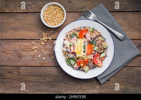 Essen Diät-Konzept, Thunfisch-Salat. Couscous-Salat mit konservierten Thunfisch, Tomaten, Gurken und lila Zwiebeln auf dem Tisch. Speicherplatz kopieren. Stockfoto