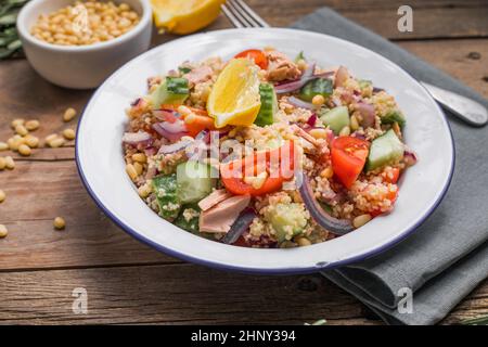 Essen Diät-Konzept, Thunfisch-Salat. Couscous-Salat mit konservierten Thunfisch, Tomaten, Gurken und lila Zwiebeln auf dem Tisch. Speicherplatz kopieren. Stockfoto