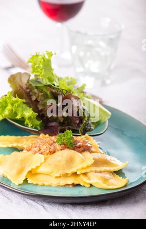 Ravioli mit Sahnesauce und Salat Stockfoto