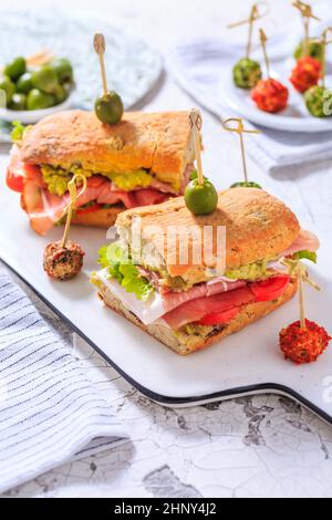 Hausgemachtes Ciabatta-Sandwich mit Guacamole, Prosciutto, Salat und Tomaten Stockfoto