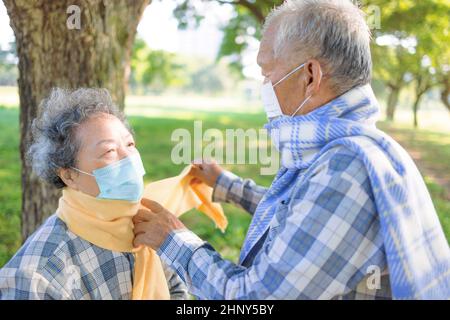 Asian Senior paar helfen sich gegenseitig tragen warme Winter Tuch Stockfoto