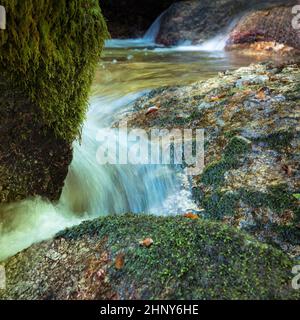 Blick auf den kleinen Wasserfall, der in Fluid Motion durch den engen Canyon fließt Stockfoto
