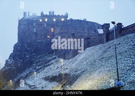 Vor dem Hintergrund des Edinburgh Castle fällt in Schottland Schnee, während der Sturm Eunice am Freitag die Südküste erreicht hat und über Großbritannien fegt. Angesichts der Schließung von Attraktionen, der Unterbrechung der Reise und der Erklärung eines größeren Vorfalls in einigen Gebieten wurden die Menschen aufgefordert, sich im Haus aufzuhalten. Bilddatum: Freitag, 18. Februar 2022. Stockfoto