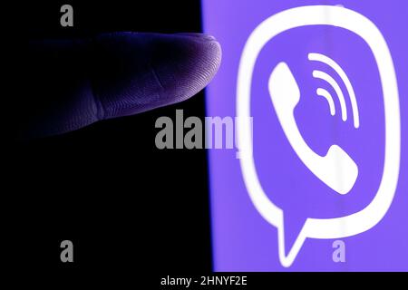 Der Finger greift nach dem Logo des Viber Instant Messaging-Dienstes auf dem Smartphone-Bildschirm. Stockfoto