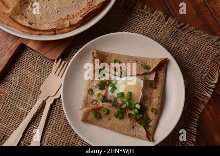 Bretonische Galette, Galette sarrasin, Buchweizenkrepe, mit Spiegelei, Käse, Schinken. Französische bretonische Küche. Stockfoto