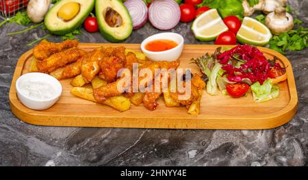 Knusprig beschichtete frittierte Hähnchenstücke mit pommes Frites und Salat Stockfoto