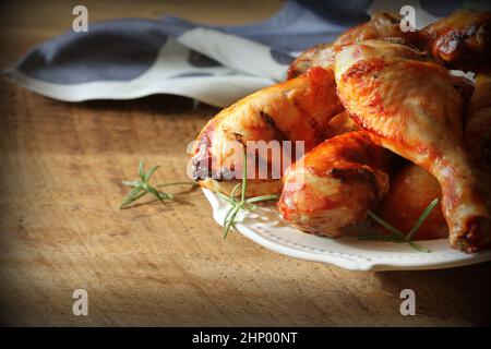 Gegrillte Hähnchenschenkel auf weiße Platte. rustikales Abendessen Hintergrund. Stockfoto