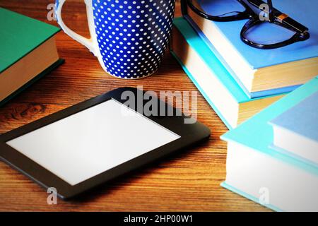 E-Book Reader und Bücher über Holz- Hintergrund. Ausbildung. Stockfoto