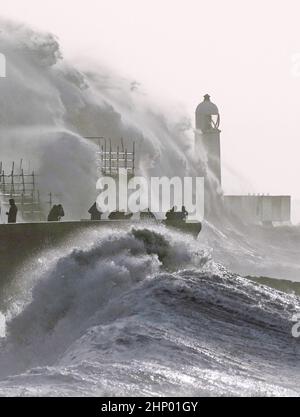 Die Wellen stürzen gegen die Meeresmauer und den Porthcawl Lighthouse in Porthcawl, Bridgend, Wales, ab, als der Sturm Eunice die Südküste trifft, wobei die Attraktionen schließen, die Reise gestört wird und in einigen Gebieten ein größerer Vorfall gemeldet wird, was bedeutet, dass die Menschen gewarnt werden, drinnen zu bleiben. Bilddatum: Freitag, 18. Februar 2022. Stockfoto