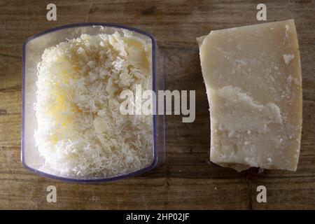 Geriebener Parmesan in einer Käseschale zusammen mit einem ganzen Stück Stockfoto