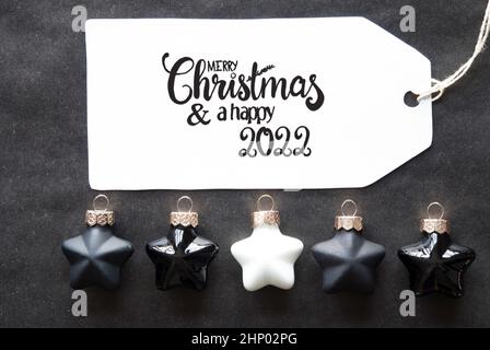 Label mit englischer Kalligraphie Frohe Weihnachten und Ein Happy 2022. Schwarzer Weihnachtskugel-Anhänger. Stockfoto