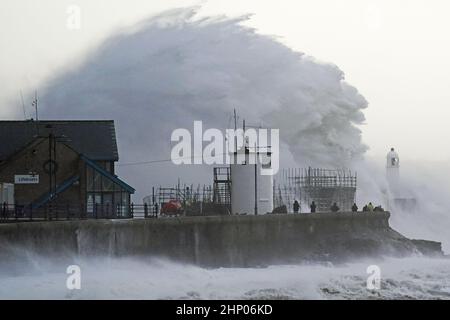 Die Wellen stürzen gegen die Meeresmauer und den Porthcawl Lighthouse in Porthcawl, Bridgend, Wales, ab, als der Sturm Eunice die Südküste trifft, wobei die Attraktionen schließen, die Reise gestört wird und in einigen Gebieten ein größerer Vorfall gemeldet wird, was bedeutet, dass die Menschen gewarnt werden, drinnen zu bleiben. Bilddatum: Freitag, 18. Februar 2022. Stockfoto
