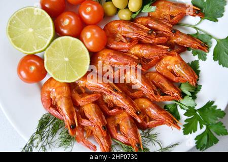 Gekochte Garnelen mit frischen Kräutern, Oliven, Limette und Tomaten Stockfoto