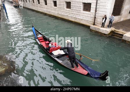 Mailand, Lombardei, Italien. 17th. Februar 2022. Touristen fotografieren einen charakteristischen Gondolier, der seine Gondel manövriert.die traditionellen Gondeln von Venedig sind eine der Haupttouristenattraktionen der Stadt Venedig. Es gibt etwa 433 Gondeln, die touristische Dienstleistungen anbieten, während es im 16th. Jahrhundert etwa 10.000 Gondeln gab, die in der Lagunenstadt zirkulierten.in jenen Jahren machten die Einwohner von Venedig die Gondel persönlich in Anspruch, Und es war die einzige Möglichkeit, sich zwischen den Kanälen zu bewegen, tatsächlich ist einer der Gründe, warum die Anzahl der Gondeln so drastisch zusammengebrochen ist, auf die Develo zurückzuführen Stockfoto