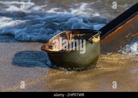 Der nasse Amcerian WW2 M1 Helm wurde am Strand zurückgelassen. D-Day Reenactment Event Day. Hel, Polen Stockfoto