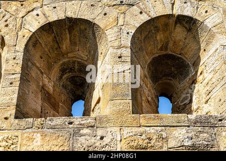 Fenster in den massiven hohen Mauern einer alten mittelalterlichen Burg Stockfoto