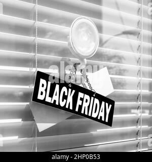 Schwarzes Freitagsschild, das vor dem Laden hängt. Black Friday Verkaufskonzept für Geschäfte. Stockfoto