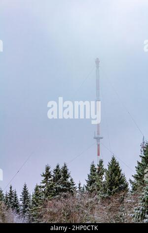 Antennenmast rot weiß im Winter und Schneesturm im Harz Wernigerode Deutschland. Stockfoto