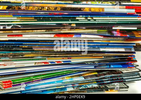 Stapel von bunten Zeitschriften auf hellem Hintergrund Stockfoto