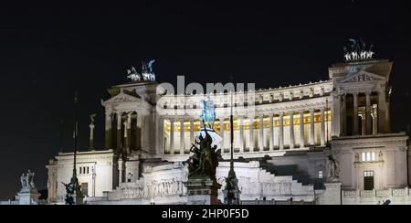 Blick auf den Vittoriano bei Nacht auf der Piazza Venezia in Rom. Nationales Denkmal und Symbol der Vereinigung Italiens, das König Vittorio Emanuel gewidmet ist Stockfoto