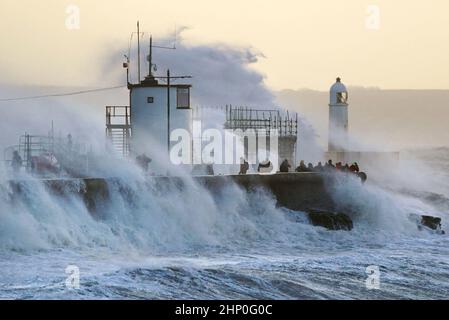 Die Wellen stürzen gegen die Meeresmauer und den Porthcawl Lighthouse in Porthcawl, Bridgend, Wales, ab, als der Sturm Eunice die Südküste trifft, wobei die Attraktionen schließen, die Reise gestört wird und in einigen Gebieten ein größerer Vorfall gemeldet wird, was bedeutet, dass die Menschen gewarnt werden, drinnen zu bleiben. Bilddatum: Freitag, 18. Februar 2022. Stockfoto