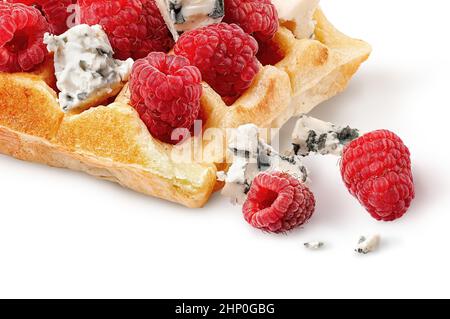 Nahaufnahme von französischen Waffeln mit Himbeeren und Dorlu-Käse. Ein paar Käsestücke und Beeren in der Nähe. Isoliert auf weißem Hintergrund Stockfoto