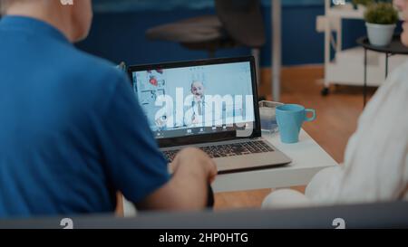 Rentnerpaar, das Online-Konsultation auf Videoanruf mit Sanitäter macht. Ältere Menschen, die einen Laptop benutzen, um sich mit einem Arzt zu treffen, um sich über Telemedizin zu unterhalten. Stockfoto