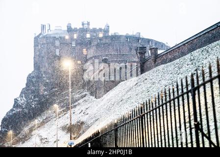 Vor dem Hintergrund des Edinburgh Castle fällt in Schottland Schnee, während der Sturm Eunice am Freitag die Südküste erreicht hat und über Großbritannien fegt. Angesichts der Schließung von Attraktionen, der Unterbrechung der Reise und der Erklärung eines größeren Vorfalls in einigen Gebieten wurden die Menschen aufgefordert, sich im Haus aufzuhalten. Bilddatum: Freitag, 18. Februar 2022. Stockfoto