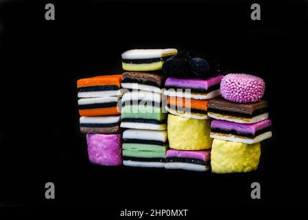 Den Helder, Niederlande. Januar 2022. Verschiedene Arten von englischem Lakritz in verschiedenen Farben vor schwarzem Hintergrund. Hochwertige Fotos Stockfoto