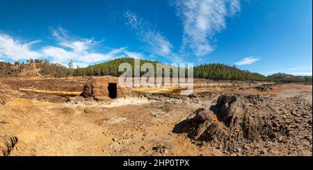 Panoramablick auf das Flussbett des Rio Tinto, einem Fluss, der die Felsen, durch die das Wasser fließt, mit gelben und orangen Farben färbt. Stockfoto