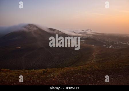 Sonnenaufgang auf Lanzarote. Handelswindwolken kommen über die Berge und lösen sich auf. Kanarische Inseln, Spanien. Stockfoto